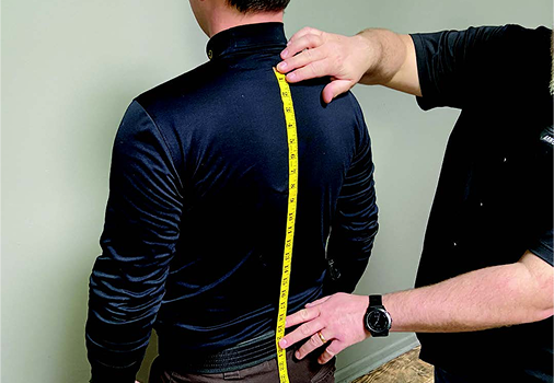 Measuring tape going up mans back
